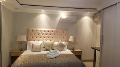 a bedroom with a large bed with white sheets and pillows at Lesolo Lodge in Burgersfort