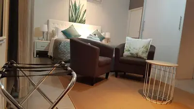 a living room with a couch and a chair at Lesolo Lodge in Burgersfort