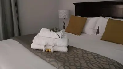 a bed with a pile of towels on it at Lesolo Lodge in Burgersfort