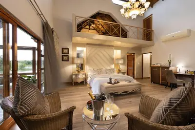 a large bedroom with a bed and a balcony at Kingfisher Villa in Mabula Game Reserve in Mabula