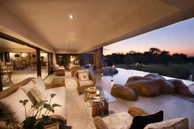a large living room with couches and a large rock at Kingfisher Villa in Mabula Game Reserve in Mabula