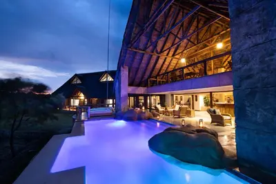 a house with a swimming pool at night at Kingfisher Villa in Mabula Game Reserve in Mabula