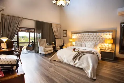 a large bedroom with a large bed and a desk at Kingfisher Villa in Mabula Game Reserve in Mabula