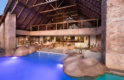an indoor swimming pool in a building with a resort at Kingfisher Villa in Mabula Game Reserve in Mabula