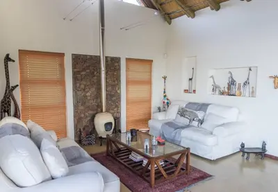 a living room with two white couches and a table at Des'lgodini Lodge - PRM078 in Bela-Bela