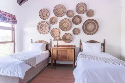 two beds in a room with plates on the wall at Des'lgodini Lodge - PRM078 in Bela-Bela