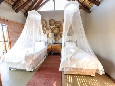 two beds with mosquito nets in a bedroom at Des'lgodini Lodge - PRM078 in Bela-Bela