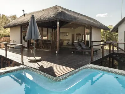 a villa with a swimming pool and a house at Des'lgodini Lodge - PRM078 in Bela-Bela
