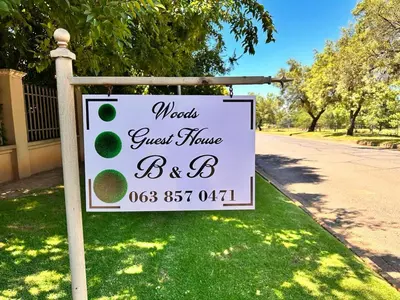 a sign for a guest house batb on a lawn at WOODS GUEST HOUSE in Middelburg