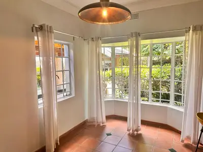 a room with two windows with curtains and a floor at WOODS GUEST HOUSE in Middelburg