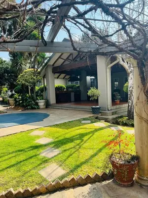 a yard with grass and plants in front of a building at WOODS GUEST HOUSE in Middelburg