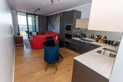 a kitchen and a living room with a red couch at Upmarket Executive Luxury Apartment in Midrand