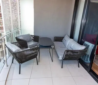 a balcony with chairs and a couch and a table at Upmarket Executive Luxury Apartment in Midrand