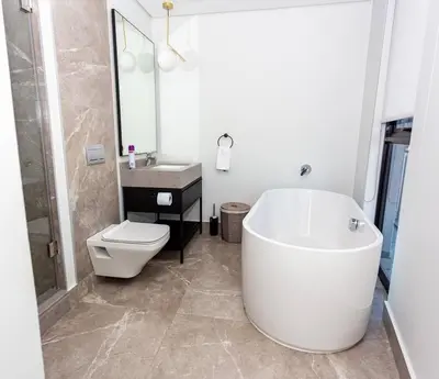 a bathroom with a tub and a toilet and a sink at Upmarket Executive Luxury Apartment in Midrand