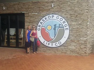 two women standing in front of a brick building at The Big tree @ Sabie in Sabie