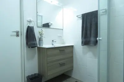 a bathroom with a sink and a shower with a mirror at Hippo's Honk at Kruger in Marloth Park