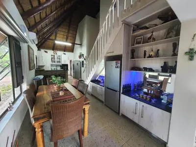 a kitchen with a dining table and a refrigerator at Hippo's Honk at Kruger in Marloth Park