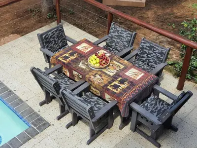 a table and chairs with a bowl of fruit on it at Hippo's Honk at Kruger in Marloth Park