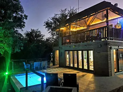 a house with a swimming pool in front of it at Hippo's Honk at Kruger in Marloth Park