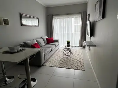 a living room with a couch and a table at Mellow-Suites Apartments 130 - WIFI and Netflix in Midrand