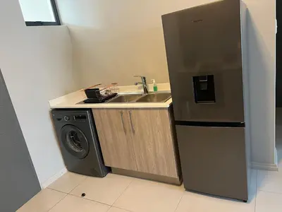 a kitchen with a sink and a washing machine at Mellow-Suites Apartments 130 - WIFI and Netflix in Midrand
