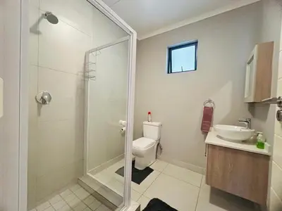 a bathroom with a shower and a toilet and a sink at Mellow-Suites Apartments 130 - WIFI and Netflix in Midrand