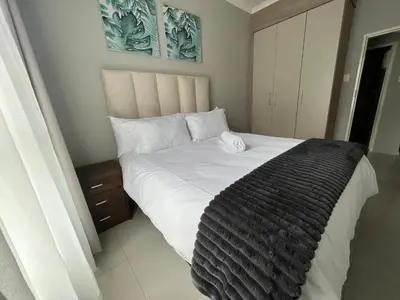 a bedroom with a large bed with white sheets at Mellow-Suites Apartments 130 - WIFI and Netflix in Midrand
