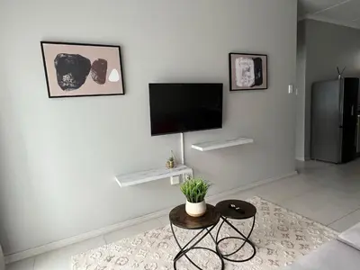 a living room with a flat screen tv on a wall at Mellow-Suites Apartments 130 - WIFI and Netflix in Midrand
