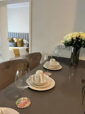 a table with plates and glasses and a vase of flowers at Spacious 2 Bedroom Apartment in Carslwald, Midrand - Business and Family friendly - 1 Harriet Place in Midrand