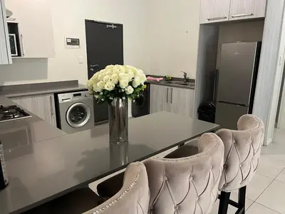 a kitchen with a table with a vase of flowers at Spacious 2 Bedroom Apartment in Carslwald, Midrand - Business and Family friendly - 1 Harriet Place in Midrand