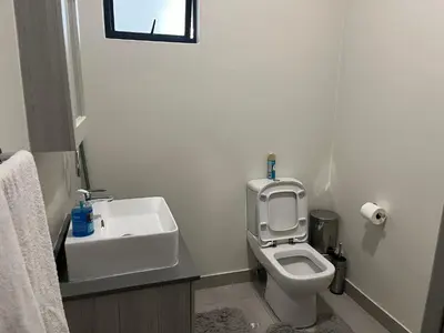a white bathroom with a toilet and a sink at Spacious 2 Bedroom Apartment in Carslwald, Midrand - Business and Family friendly - 1 Harriet Place in Midrand