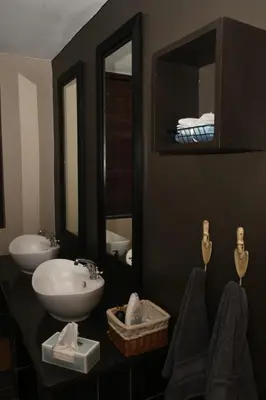 a bathroom with a sink and two mirrors at Tranquil Garden Nest in Nelspruit