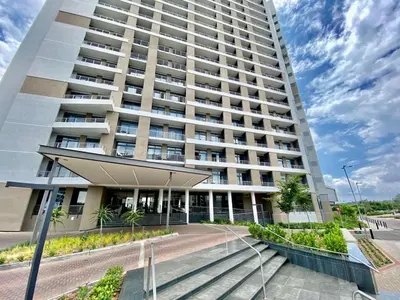 a large white building with a staircase in front of it at Triology Menlyn Maine Residences in Pretoria