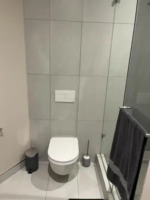 a white bathroom with a toilet and a shower at Triology Menlyn Maine Residences in Pretoria