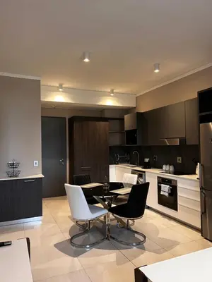 a kitchen with a table and chairs in a room at Triology Menlyn Maine Residences in Pretoria