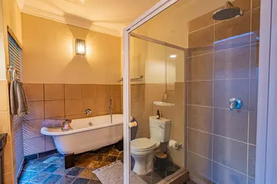 a bathroom with a tub and a toilet and a sink at Kubu Lodge in Mabula