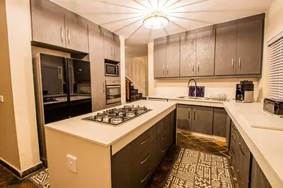 a kitchen with wooden cabinets and a stove top oven at Kubu Lodge in Mabula