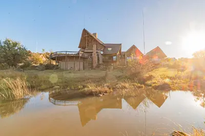 an old house with a pond in front of it at Kubu Lodge in Mabula