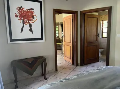 a bedroom with a bed and a picture on the wall at SHONALANGA - Secured cottage in equestrian estate - LOADSHEDDING FREE! in Midrand