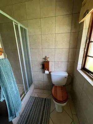 a bathroom with a toilet and a shower at SHONALANGA - Secured cottage in equestrian estate - LOADSHEDDING FREE! in Midrand