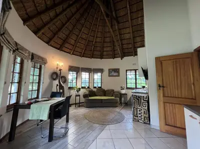 a living room with a couch and a wooden ceiling at SHONALANGA - Secured cottage in equestrian estate - LOADSHEDDING FREE! in Midrand