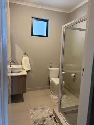 a bathroom with a toilet and a sink and a mirror at Mellow-Suites Apartments - 31 - WIFI and Netflix in Midrand