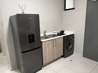 a kitchen with a stainless steel refrigerator and a washing machine at Mellow-Suites Apartments - 31 - WIFI and Netflix in Midrand
