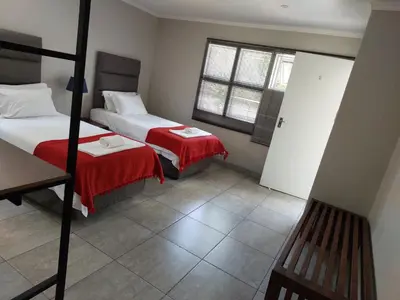 a small room with two beds and a window at Stay@603 Guesthouse in Pretoria