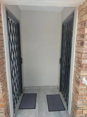 a pair of doors in a room with a brick wall at Stay@603 Guesthouse in Pretoria