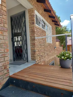 a wooden deck in front of a building with a door at Stay@603 Guesthouse in Pretoria