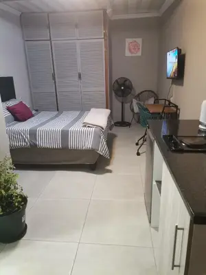 a living room with a bed and a kitchen at Comfort place 2 in Pretoria