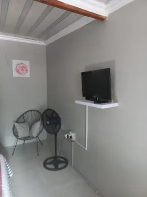 a living room with a tv and a chair at Comfort place 2 in Pretoria