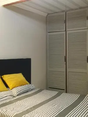 a bedroom with a bed with a yellow pillow at Comfort place 2 in Pretoria