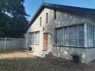 a white house with a red door and a fence at Comfort place 2 in Pretoria
